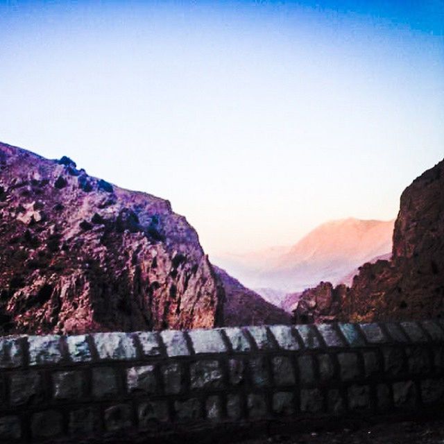 mountain, clear sky, copy space, mountain range, tranquil scene, tranquility, scenics, beauty in nature, rock - object, nature, railing, rock formation, blue, landscape, non-urban scene, sky, outdoors, idyllic, rocky mountains, sunlight