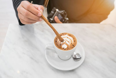 Hand holding coffee cup on table