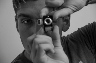 Close-up portrait of young man holding camera