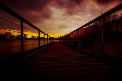 Bridge over calm sea against sky during sunset