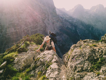 Rear view of woman on cliff against mountains