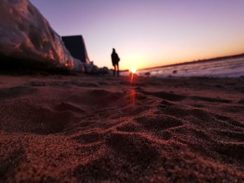 Silhouette of man on beach against sky during sunset