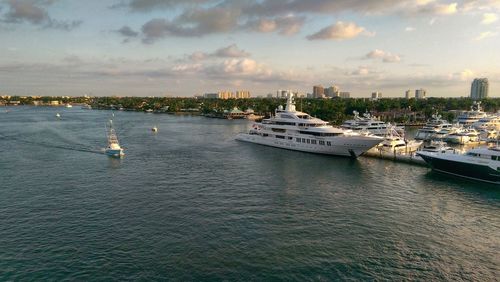 Boats in sea against cloudy sky