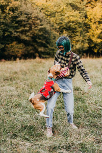 Side view of woman with dog on field