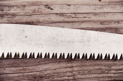 Close-up of saw on wooden table
