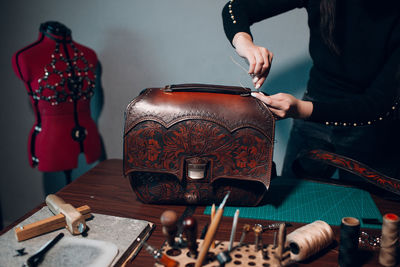 Midsection of young fashion designer working at workshop