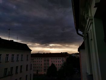 Silhouette buildings against sky at sunset