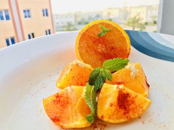 Close-up of orange slices in plate on table