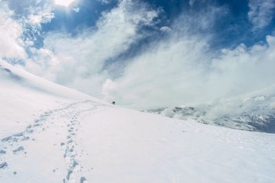 Snow covered landscape against sky