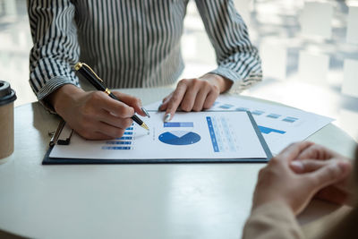 Midsection of business colleagues working on table