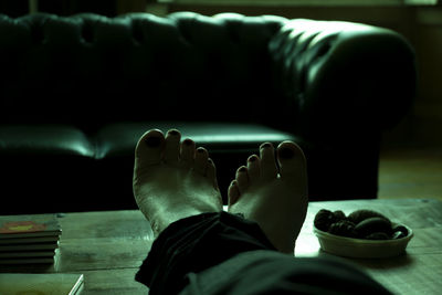 Low section of woman relaxing in living room at home