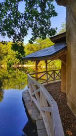 Chair and table by lake against sky