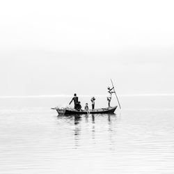 People in boat on sea against sky