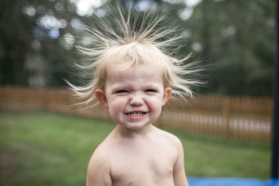 Close up of smiling toddler girl with static hair outdoors