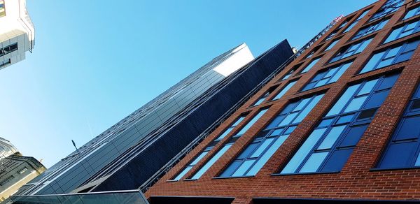 Low angle view of modern building against clear blue sky