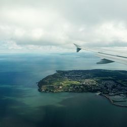 Airplane flying over sea against sky