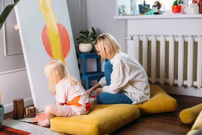 Young woman artist is painting at home in a creative studio setting.