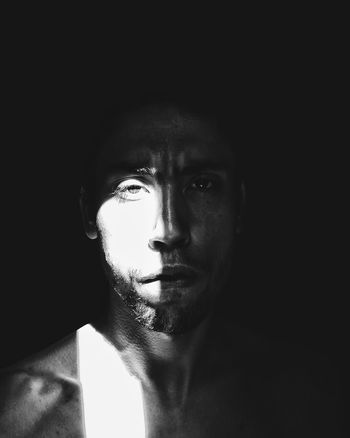 CLOSE-UP PORTRAIT OF MAN IN BLACK BACKGROUND