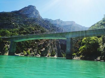 Scenic view of river by mountains against sky