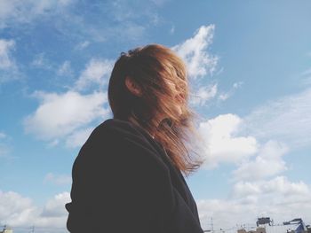 Portrait of woman looking at camera against sky