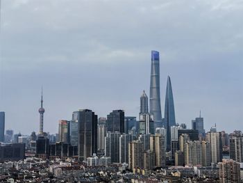 Modern buildings in city against cloudy sky