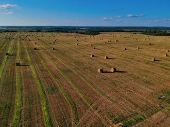 Hay bales on field against sky