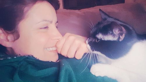 Happy young woman with cat at home