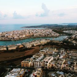 High angle view of townscape by sea against sky