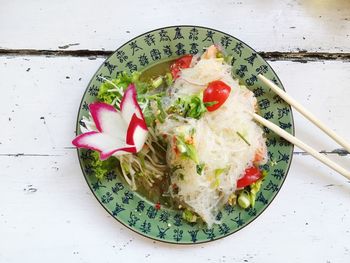 Directly above shot of thai food served in plate on wooden table