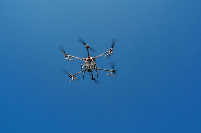 Agricultural drone in flight on a background of blue sky. field spraying new technologies.