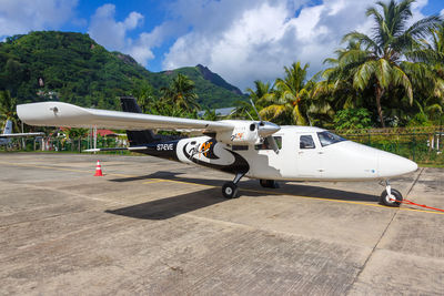 Airplane on airport runway against sky