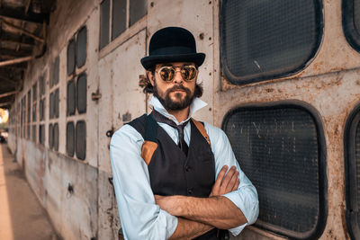 Full length portrait of young man standing against built structure