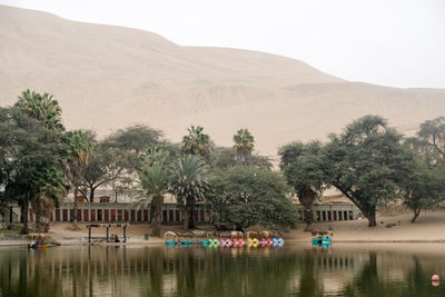 Scenic view of lake by buildings against sky