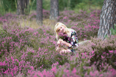 Portrait of woman holding lavender flower at field