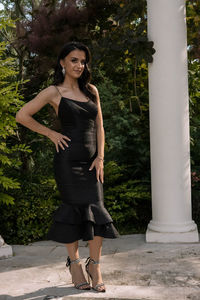 Full length portrait of woman standing by tree