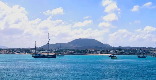 Sailboats in sea against sky