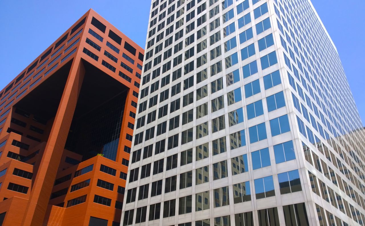 building exterior, architecture, built structure, low angle view, modern, city, office building, window, building, clear sky, tall - high, skyscraper, glass - material, tower, reflection, outdoors, day, pattern, architectural feature, no people