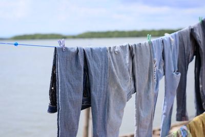 Close-up of clothes drying on wooden post against sky