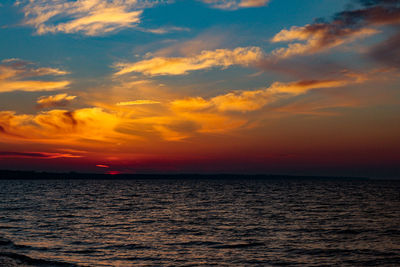 Scenic view of sea against dramatic sky during sunset