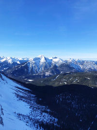 Scenic view of snowcapped mountains against clear blue sky