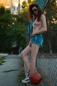 Portrait of young woman standing on road