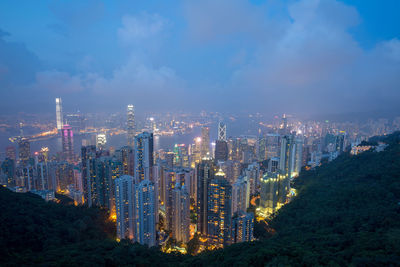 Illuminated buildings in city against sky