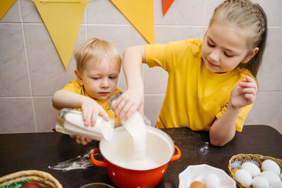 Kids prepare dough for holiday cupcake holiday easter, eggs on the table