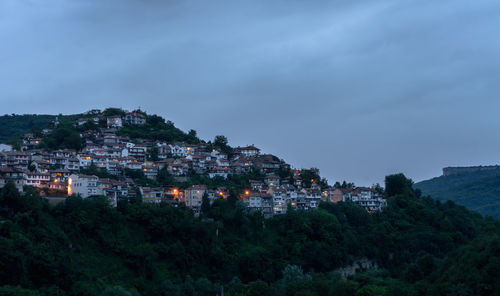 Buildings in town against sky at dusk