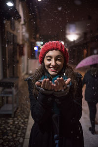 Smiling young woman standing in snow