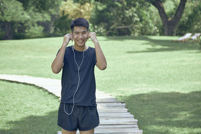 Portrait of a smiling young man standing on grass