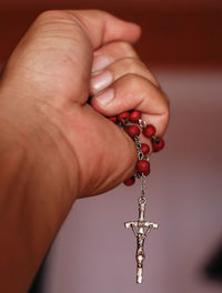 Close-up of hand holding rosary beads