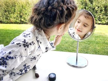 Close-up of girl looking in mirror