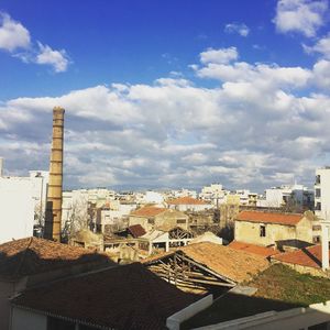 Buildings in city against cloudy sky