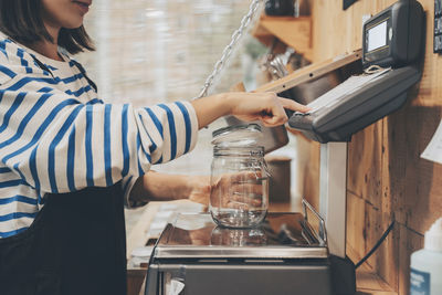 Customer weighing empty mason jar in zero waste store